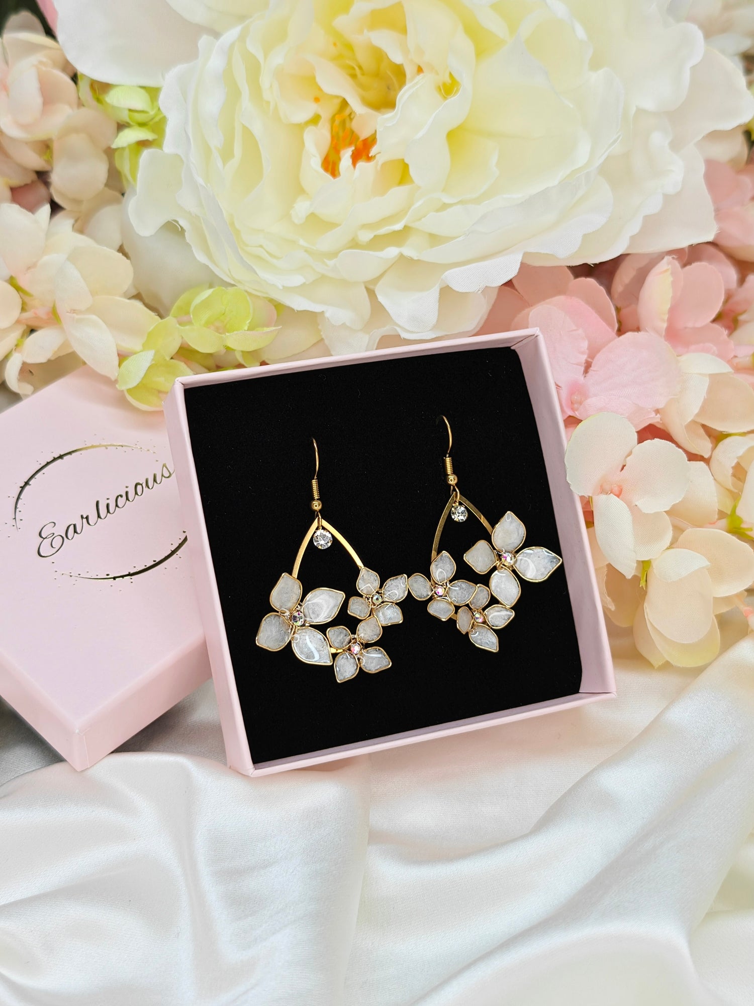 Käsintehdyt kotimaiset Earlicious kukkakorvakorut.